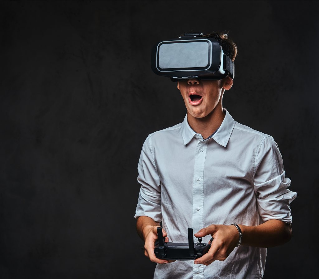Головна joyful teenager dressed white shirt wears virtual reality glasses controls quadcopter using control remote isolated dark background